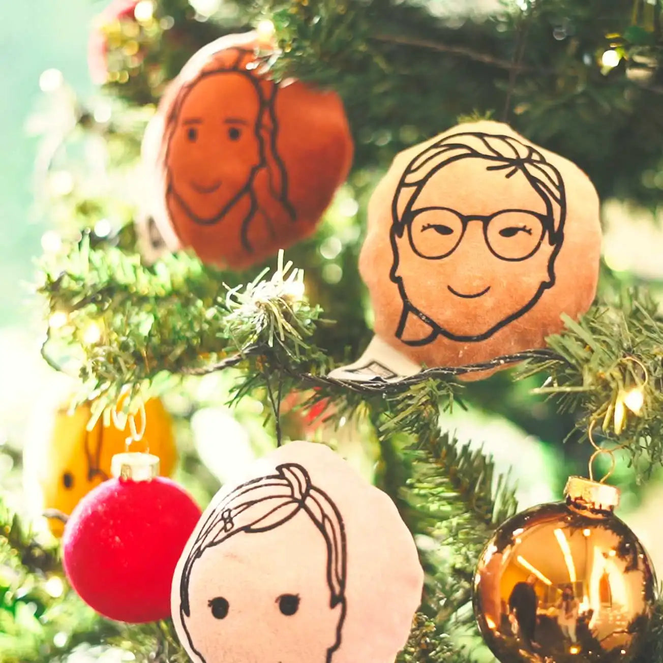 Verschillende kerstportretjes die in de boom hangen