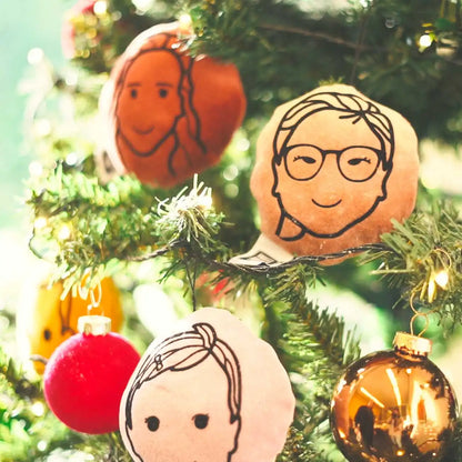 Verschillende kerstportretjes die in de boom hangen