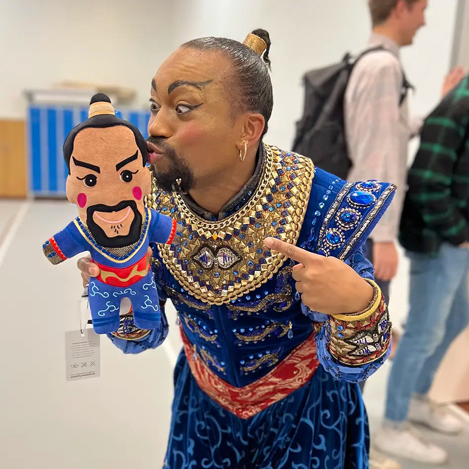 Nigel Brown als de Geest van Aladdin de Musical samen met zijn eigen knuffelportretje waarin ook zijn hele outfit gelijkend is gemaakt.