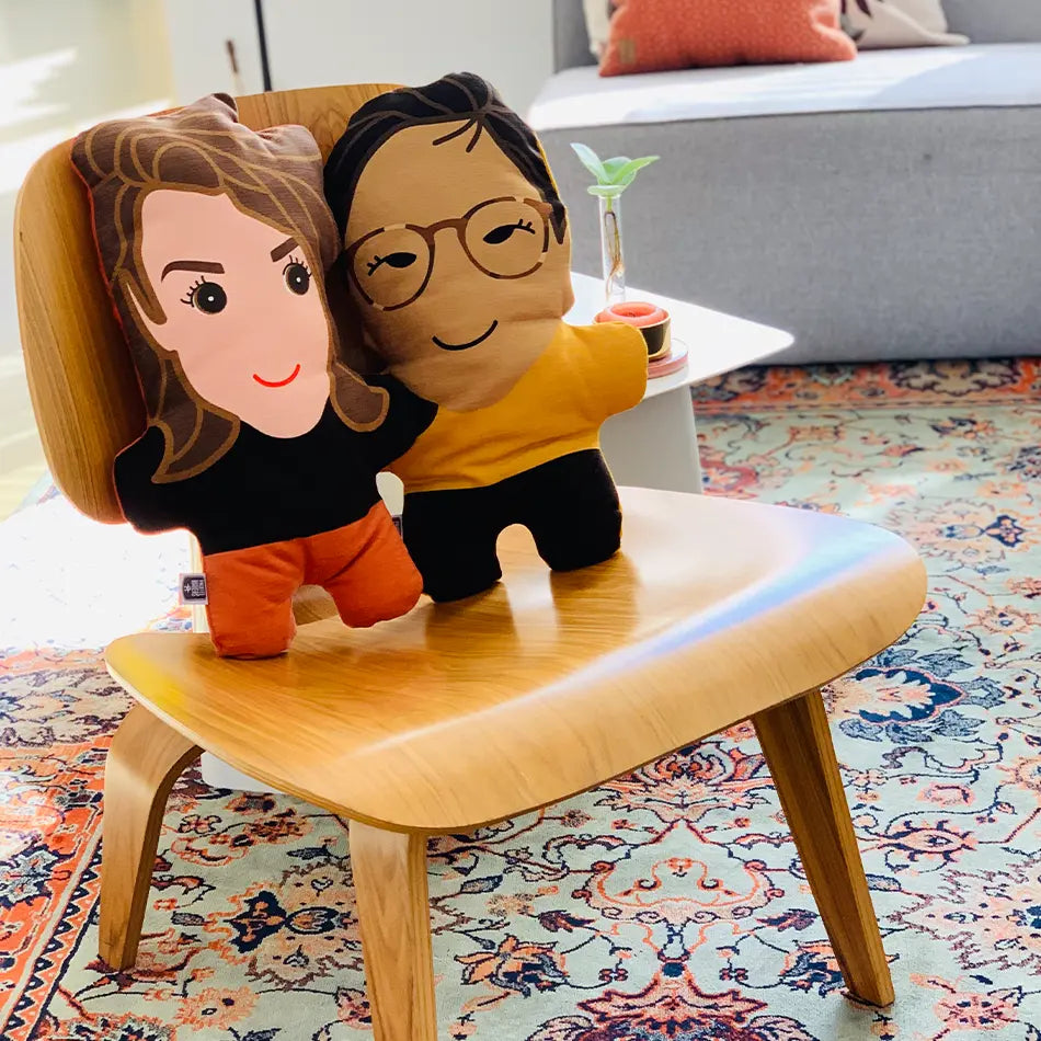 Twee kussenportretten van personen op een stoel